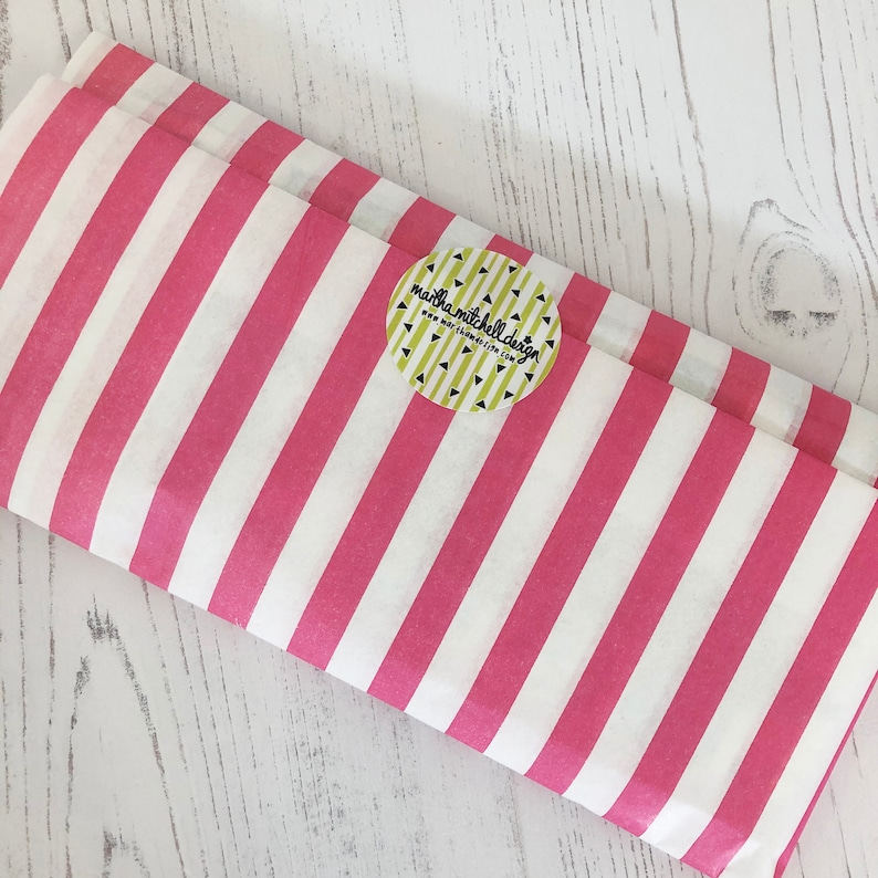 Może przedstawiać: R&oacute;żowy i biały papier tiulowy w paski z okrągłą naklejką z napisem "martha mitchell design" i "www.marthamitchell.com".