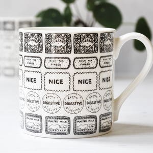 Puede incluir: Taza de cerámica blanca con un diseño en blanco y negro de varias marcas de galletas, incluyendo "Custard Cream", "Rich Tea Finger", "Nice" y "Digestive".