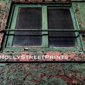 May include: Close-up of a weathered, green-painted window frame with two panes and a horizontal bar. The paint is peeling, revealing a reddish-brown layer beneath. The text "HOLLYSTREETPRINTS" is visible.