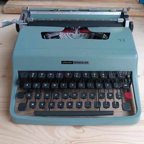 Olivetti Lettera 32 typewriter in perfect condition. Includes original Olivetti typing instruction book.