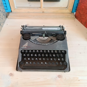Máquina de escribir HERMES BABY: icónico modelo metálico de los años 50, totalmente funcional, con estuche metálico.