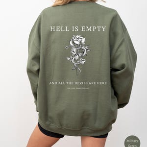 May include: Military green sweatshirt with the text "HELL IS EMPTY" above a black and white rose and snake graphic. Below the graphic is the text "AND ALL THE DEVILS ARE HERE" and "WILLIAM SHAKESPEARE".