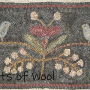 May include: A rectangular, hand-hooked rug with a dark gray background. The rug features two light blue birds perched on a brown vine with floral and leaf accents in pink, green, and cream. The border is a dark red. The text "Baskets of Wool" is at the bottom.