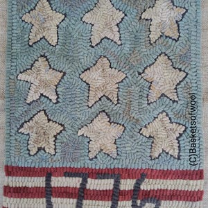 May include: A handmade rug with a patriotic theme. The rug features nine off-white stars on a light blue background. The bottom has red and white stripes with the number "1776" in dark blue.