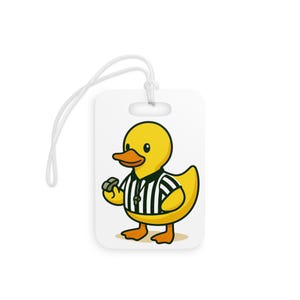 May include: White luggage tag featuring a cartoon yellow duck wearing a referee uniform with a whistle. The duck has an orange beak and feet. A white string is attached to the top of the tag.