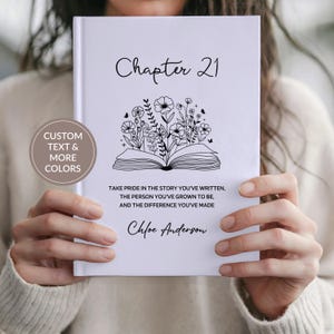 May include: A white journal with the text "Chapter 21" and floral illustrations. The journal also includes the text "Take pride in the story you've written, the person you've grown to be, and the difference you've made" and the name "Chloe Anderson."