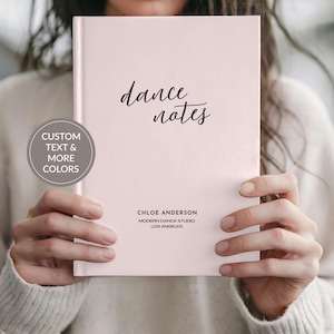 May include: A light pink notebook with the words "dance notes" in elegant script. The notebook also features the text "Chloe Anderson Modern Dance Studio Los Angeles". A circular graphic on the left says "Custom Text & More Colors".
