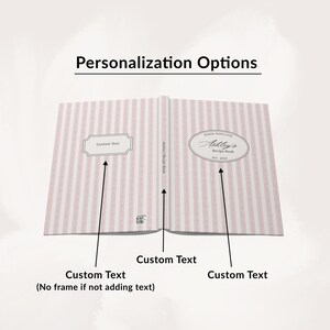 May include: Open recipe book with pink and white striped pages. The book is labeled "Ashley's Recipe Book" and includes areas for custom text. The cover displays "Baked with Love" and "Est. 2020".