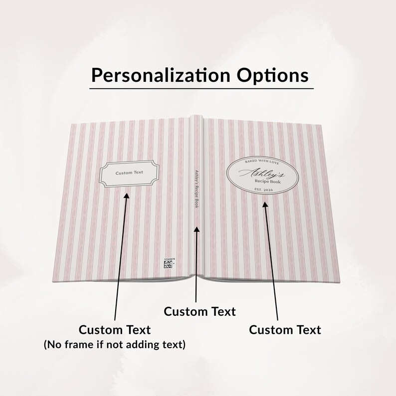 May include: Open recipe book with pink and white striped pages. The book is labeled "Ashley's Recipe Book" and includes areas for custom text. The cover displays "Baked with Love" and "Est. 2020".