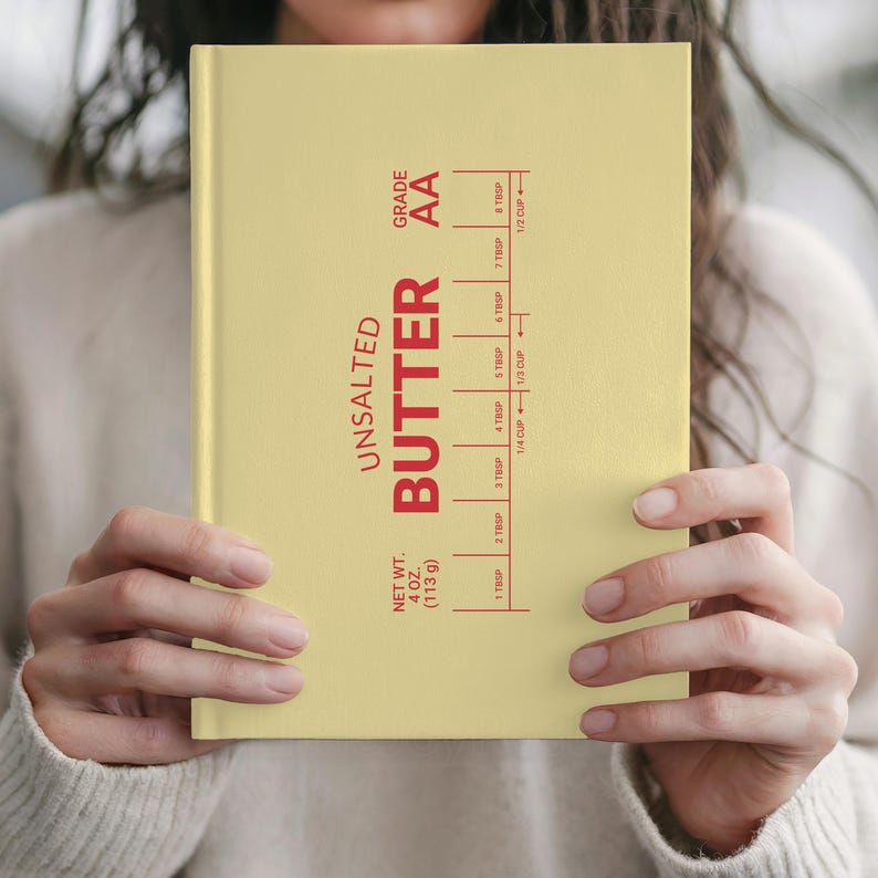 Puede incluir: Un cuaderno amarillo con las palabras "UNSALTED BUTTER" en rojo, junto con marcas de medici&oacute;n. El cuaderno tambi&eacute;n incluye el texto "NET WT. 4 OZ. (113 g)" y "GRADE AA".