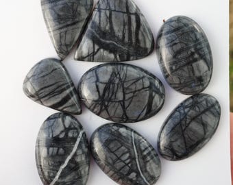 May include: A collection of polished gray stones with black veining. The stones vary in shape, including oval, teardrop, and triangular forms. The natural patterns create a unique, marbled appearance. These stones are suitable for jewelry making or decorative purposes.