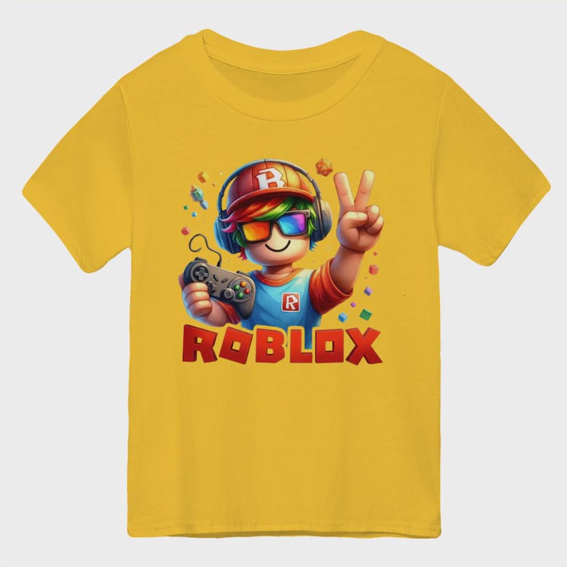 May include: Yellow short-sleeve t-shirt featuring a cartoon character with headphones, rainbow-colored glasses, and a game controller. The character is giving a peace sign. The word "ROBLOX" is printed in red and orange block letters.