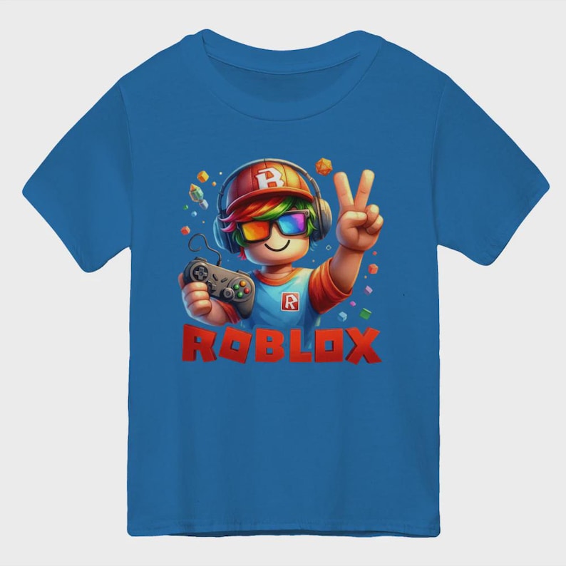 May include: Blue t-shirt featuring a cartoon character with a headset, rainbow glasses, and a controller. The character is giving a peace sign. The word "ROBLOX" is printed in red block letters.