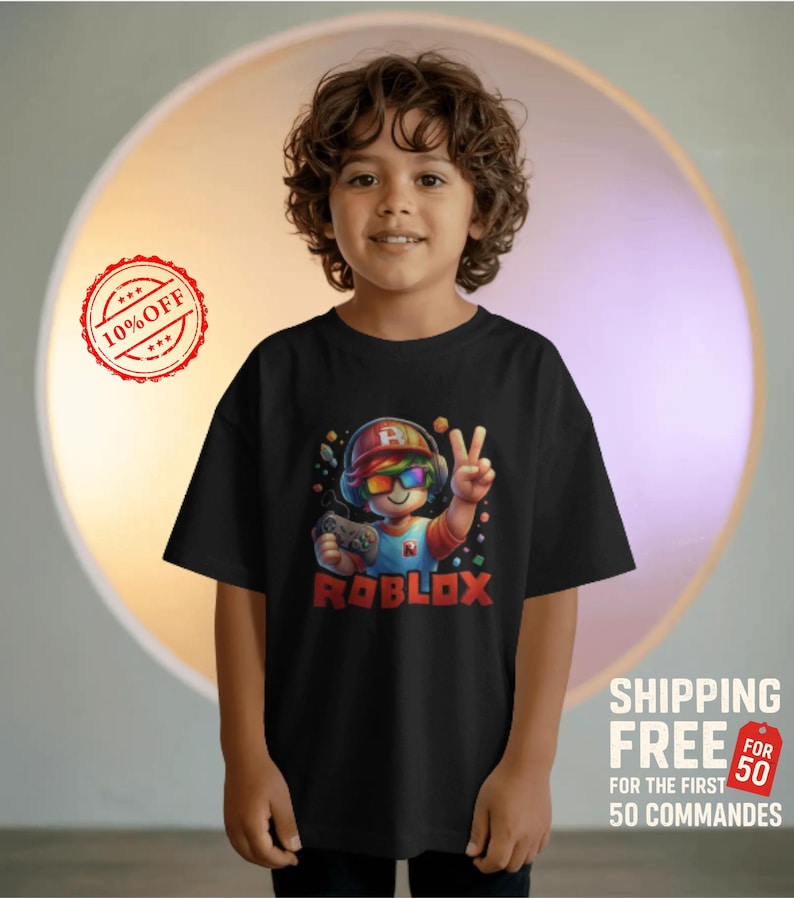 May include: Black t-shirt featuring a colorful Roblox character with rainbow sunglasses, a red and blue hat, and a controller. The word "ROBLOX" is printed in red. The shirt is worn by a child.