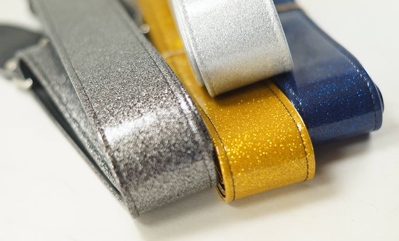 Pu&ograve; includere: Quattro nastri di diversi colori con una finitura scintillante. I nastri sono argento, oro, grigio scuro e blu navy.