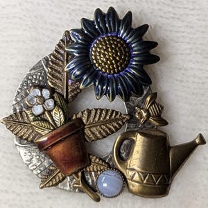 Vintage blandad metallbrosch i trädgårdscollage – blå spetsagat, solros, honungsbi, vattenkanna