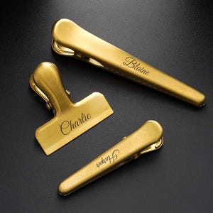 May include: A white ceramic mug with a black handle and the text "But First, Coffee" in a black, bold font. The mug is on a white surface.