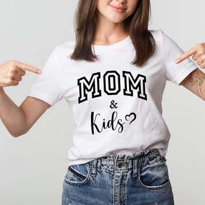 May include: White t-shirt with black text that reads "MOM & Kids" with a heart symbol.