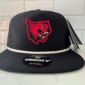 Peut inclure: Casquette de baseball noire avec un logo de couguar rouge et noir brodé. La casquette a une visière plate, un détail de corde blanche et une étiquette. La marque "DECKY" est visible sur un autocollant sur le bord.