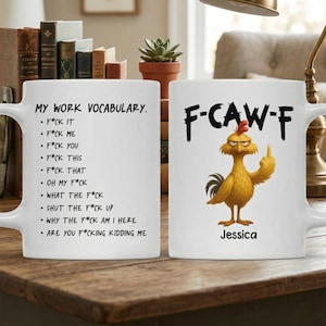 May include: White ceramic mug with the text "MY WORK VOCABULARY" and a list of expletives. The other side features a cartoon rooster giving the middle finger, with the text "F-CAW-F" and the name "Jessica".