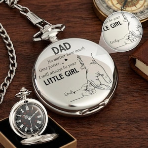 May include: A silver pocket watch with a black face and Roman numerals, displayed open in a box. The watch face reads "DAD, No matter how much time passes, I will always be your LITTLE GIRL, Emily, Dennis."