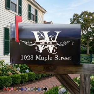 May include: A black mailbox with a red flag displays the address "1023 Maple Street" and the name "Williams" in white script. The mailbox is mounted on a wooden post and surrounded by greenery.