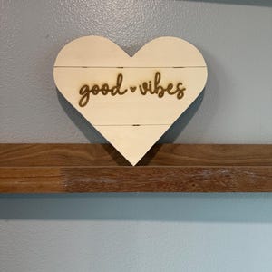 木にレーザー彫刻されたハート型のGood Vibesサイン