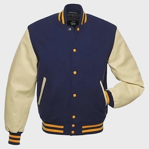 May include: A navy blue varsity jacket with cream-colored sleeves. The jacket features gold and navy striped trim on the cuffs and hem, and gold buttons down the front. The collar is navy blue with gold trim. The jacket has a classic, sporty look.