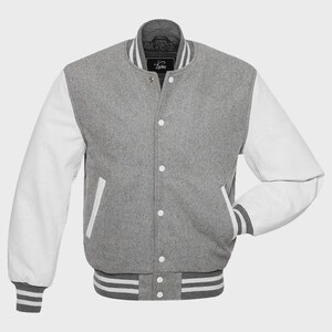May include: A gray varsity jacket with white sleeves. The jacket has a button-up front, a ribbed collar, cuffs, and waistband with white stripes. The jacket has two front pockets and a small label near the collar.