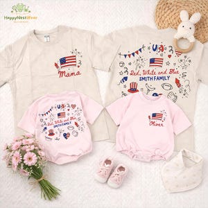 Op de afbeelding: Een verzameling kleding met een patriottisch thema, waaronder twee beige t-shirts en twee roze rompertjes. De shirts hebben Amerikaanse vlagontwerpen en de tekst "Mama" en "Red, White and Blue SMITH FAMILY". De rompertjes hebben vergelijkbare afbeeldingen en de tekst "Oliver".