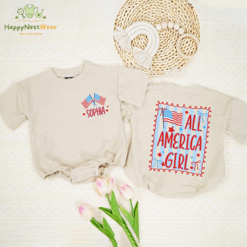Puede incluir: Dos peleles beige para beb&eacute;. Uno tiene el nombre "Sophia" y dos banderas americanas bordadas en la parte delantera. El otro tiene "ALL AMERICA GIRL" con un dise&ntilde;o de bandera americana en la parte trasera. Los peleles son de manga corta.