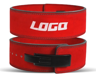 May include: Two red weightlifting belts stacked on top of each other. The top belt has the word "LOGO" in white block letters. The belts have black stitching and a black buckle. The belts are made of a suede-like material.