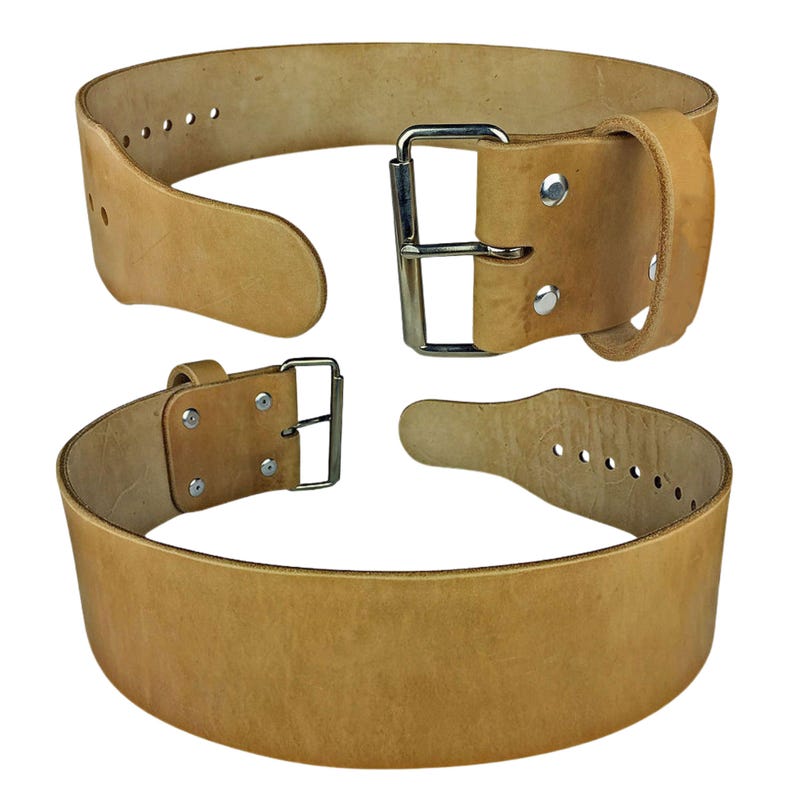 Peut inclure: Une ceinture d'halt&eacute;rophilie en cuir beige avec une boucle et des rivets argent&eacute;s. La ceinture est &eacute;paisse et robuste, con&ccedil;ue pour soutenir pendant les exercices de levage lourds. La ceinture est pr&eacute;sent&eacute;e en deux parties, d&eacute;boucl&eacute;e.
