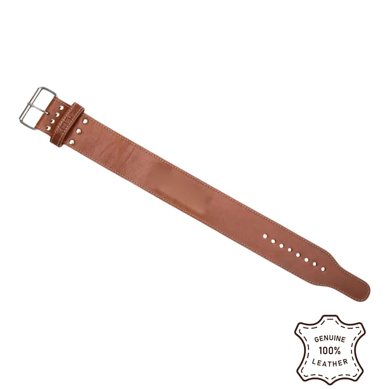 Peut inclure: Une ceinture d'halt&eacute;rophilie en cuir marron avec une boucle et des rivets argent&eacute;s. La ceinture a une forme rectangulaire avec une s&eacute;rie de trous pour le r&eacute;glage. Le coin inf&eacute;rieur droit de l'image porte un tampon indiquant "GENUINE 100% LEATHER."