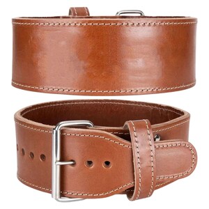 Peut inclure: Deux vues d'une ceinture d'halt&eacute;rophilie en cuir marron. La ceinture est &eacute;paisse, avec des coutures blanches sur les bords. Elle poss&egrave;de une boucle m&eacute;tallique et plusieurs trous de r&eacute;glage. La vue de dessus montre l'ext&eacute;rieur de la ceinture, tandis que la vue de dessous montre la ceinture attach&eacute;e.