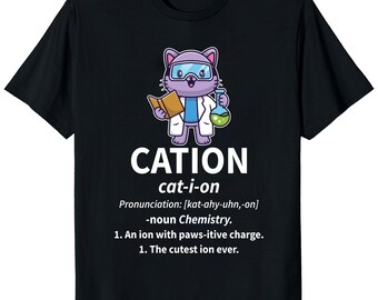 May include: Black t-shirt featuring a cartoon cat in a lab coat and goggles, holding a book and a flask. The word "CATION" is above the cat, with the pronunciation and definition below. The shirt is a science-themed design.