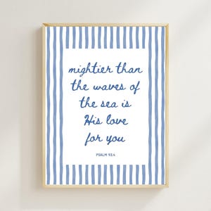 May include: A framed print with a light wood frame. The artwork features blue and white vertical stripes around a white center with the text "mightier than the waves of the sea is His love for you" and "PSALM 93:4" in blue script.