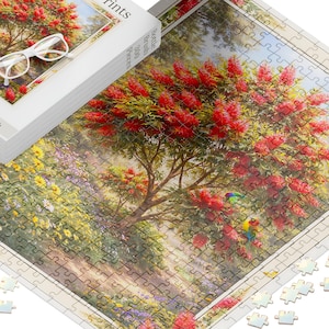 May include: A 300-piece jigsaw puzzle featuring a vibrant garden scene with a large bottlebrush tree displaying bright red flowers and green foliage, accompanied by colourful lorikeets. The puzzle box shows the same image with white glasses.