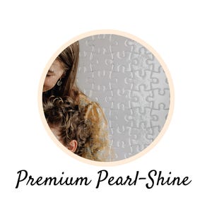 May include: A circular image featuring a person with long, wavy hair and a patterned top, set against a backdrop of a puzzle. The text "Premium Pearl-Shine" is written in a cursive font below the circle.