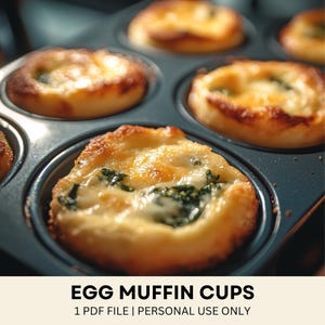 May include: Close-up of baked egg muffin cups in a dark blue muffin tin. The muffins have a golden-brown crust with visible cheese and spinach filling. The text "EGG MUFFIN CUPS" is displayed at the bottom of the image.