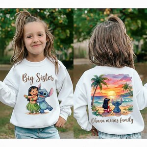 May include: White sweatshirt featuring the text "Big Sister" and a cartoon graphic of Lilo and Stitch on the front. The back displays a beach scene with palm trees, sunset, and the text "Ohana means family".
