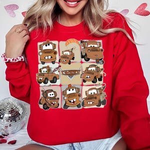 Może przedstawiać: Czerwona bluza z siatką dziewięciu brązowych kresk&oacute;wkowych lawet. Słowo "Cars" jest wyświetlane w kształcie rombu. Bluza jest w jednolitym czerwonym kolorze.