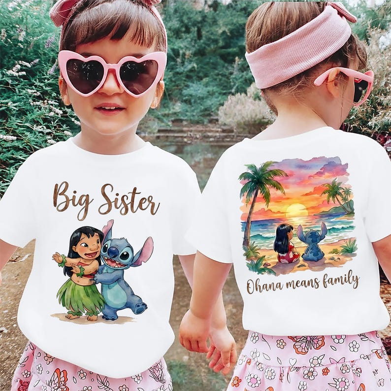 May include: White t-shirts featuring Lilo and Stitch graphics. One shirt says "Big Sister" and shows Lilo and Stitch. The other has a beach scene with Lilo and Stitch and the text "Ohana means family."