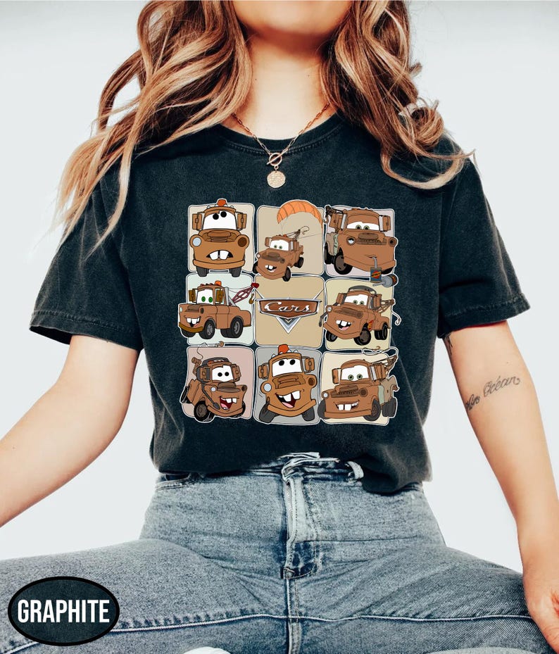 Może przedstawiać: Ciemnoszara koszulka z siatką brązowych kresk&oacute;wkowych lawet z napisem "Cars" pośrodku. Koszulka wykonana jest z miękkiego materiału i nadaje się do noszenia na co dzień.