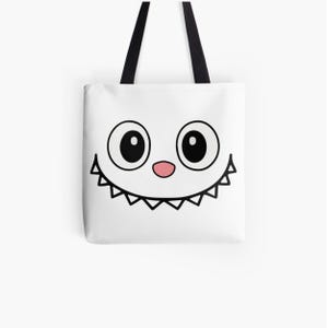 Puede incluir: Bolso tote blanco con un dise&ntilde;o de cara de dibujos animados. Presenta ojos negros grandes, una nariz rosa y una sonrisa dentada. El bolso tiene asas negras y est&aacute; dise&ntilde;ado para transportar objetos.