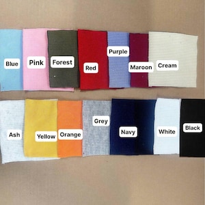 Puede incluir: Muestras de tela en varios colores: azul, rosa, verde bosque, rojo, morado, granate, crema, ceniza, amarillo, naranja, gris, azul marino, blanco y negro. Cada muestra tiene una etiqueta con su nombre de color.