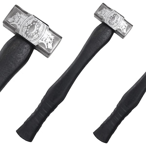Könnte beinhalten: Zwei Hämmer mit schwarzen Stielen und silbernen Köpfen. Die Köpfe sind mit einem Design aus zwei sich gegenüberstehenden Wölfen, einem Halbmond und einem Kreis aus Sternen graviert.