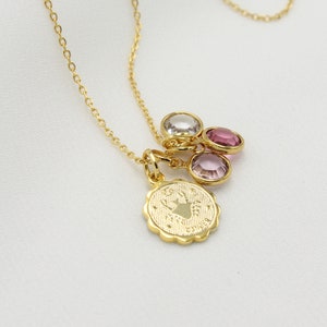 May include: Gold chain necklace with a charm featuring a zodiac symbol and three small pink and clear gemstones.