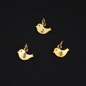 May include: Three gold bird charms with the letters J, S, and N engraved on them.
