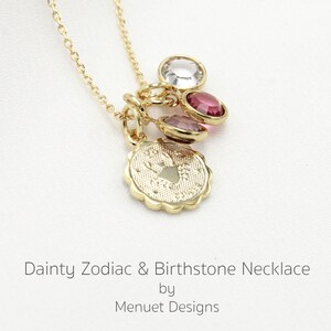 May include: Gold necklace with a zodiac charm and three birthstone charms. The zodiac charm is a crab, representing the Cancer sign. The birthstones are clear, pink, and red.